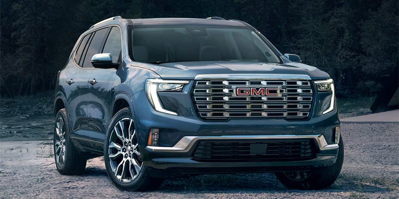 Blue GMC SUV parked on a rough dirt road